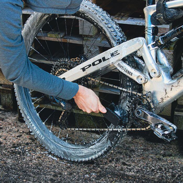 Using the Juice Lubes Dirt Daddy - Tyre & Cassette Brush and soap to clean a mountain bike tyre